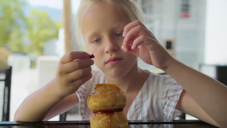 little girl enjoying a delicious cream puff dessert