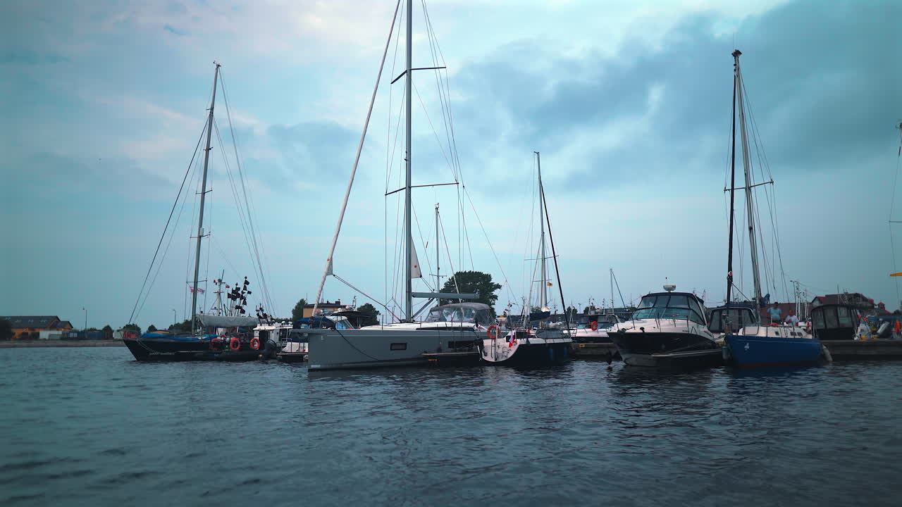 pov shot of luxurious yachts moored in the marina at summer day