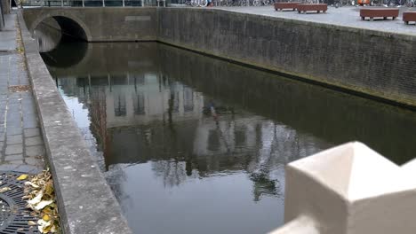 Lift-up-from-the-bridge-railing-to-a-wide-shote-of-a-dutch-canal