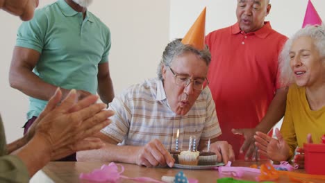 Happy-senior-diverse-people-at-birthday-party-with-cake-at-retirement-home