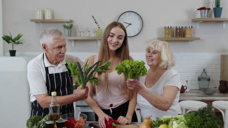 Girl-with-mature-man-and-woman-recommending-eating-raw-vegetable-food.-Healthy-nutrition-diet