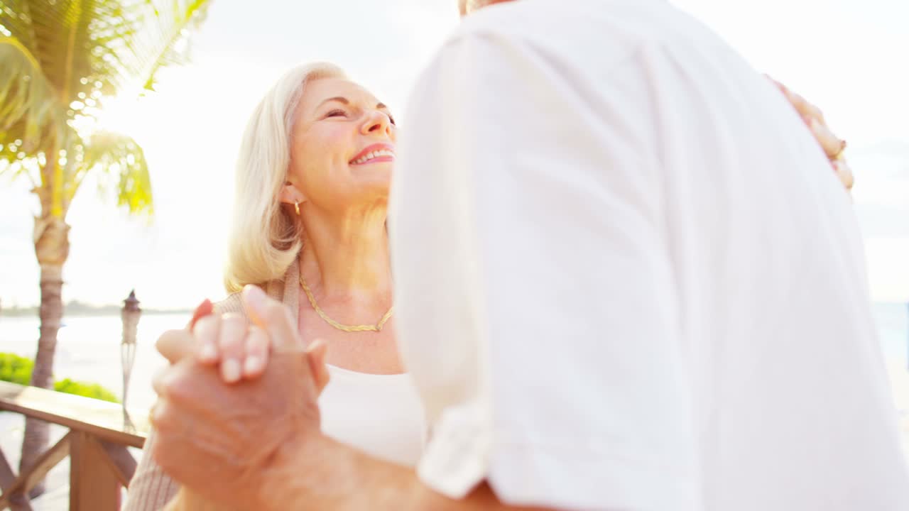 una pareja caucásica senior bailando juntos en la playa del caribe.