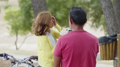 Back-view-of-senior-man-photographing-his-wife-on-phone-in-park