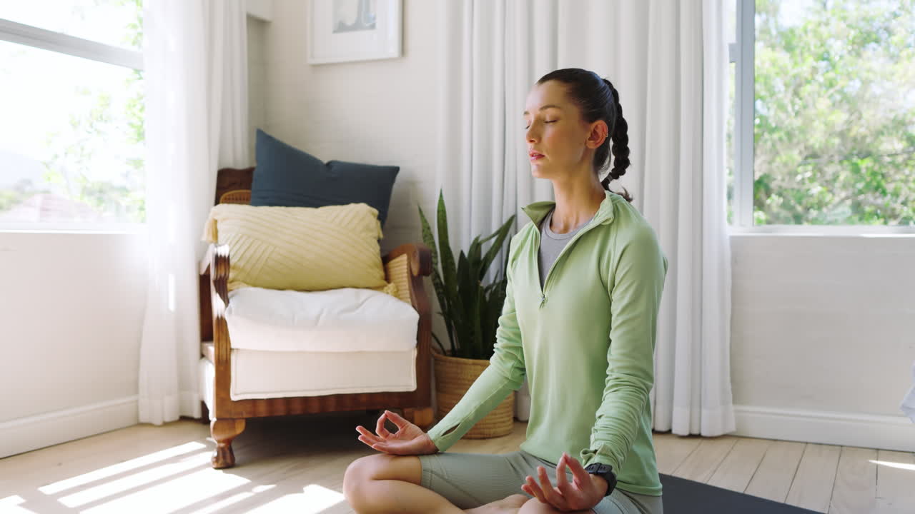 Woman meditating on yoga mat at home, embracing peaceful relaxation