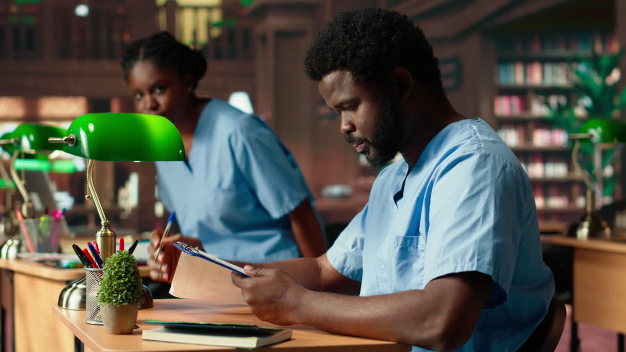 Medical assistant student reading under a green lamp in the library