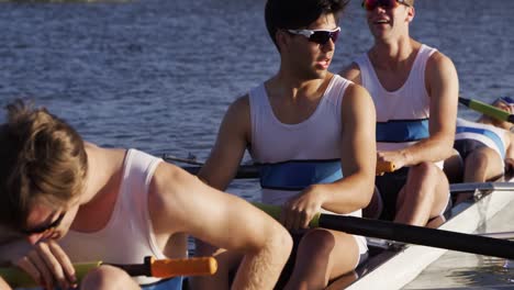 front view of male rower team resting on the lake