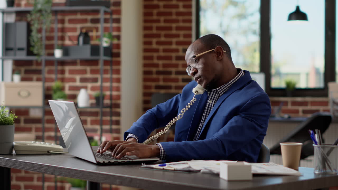 Male secretary answering landline phone call at startup job