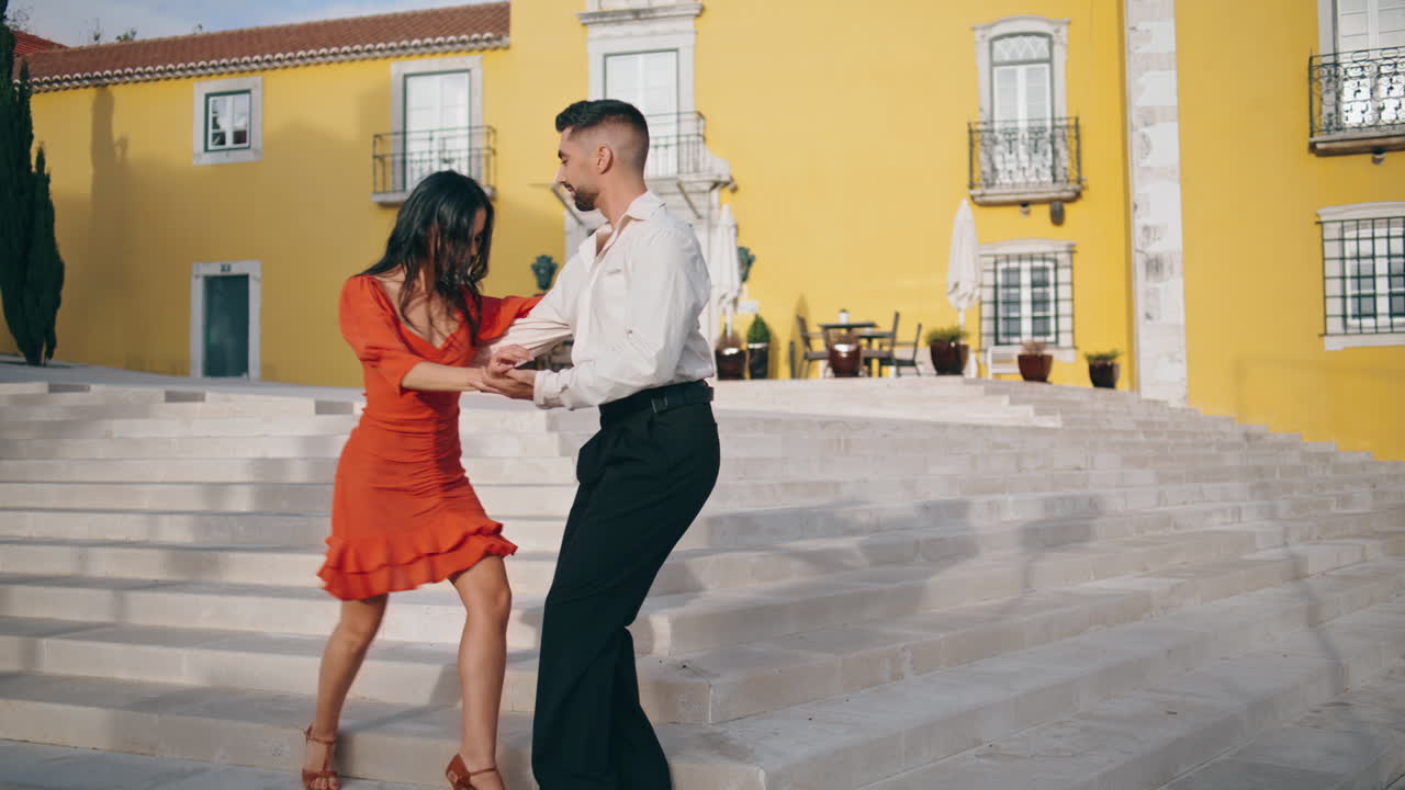 artistas practicando danza latina en las escaleras de la ciudad. una pareja feliz bailando al aire libre.