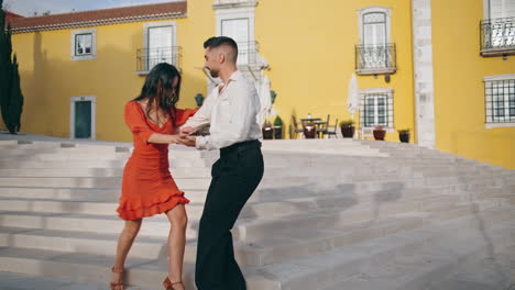 latin performers practicing dance on town stairs. happy couple dancing outdoors.