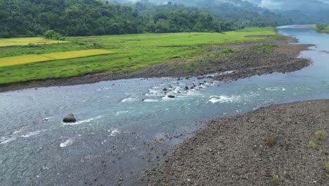 Vista-Aérea-Del-Río-Con-Aguas-Poco-Profundas-Y-Campos-Verdes-En-Catanduanes,-Filipinas