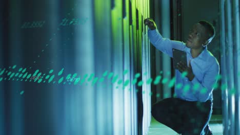 Animation of data processing over african american male engineer using digital tablet at server room