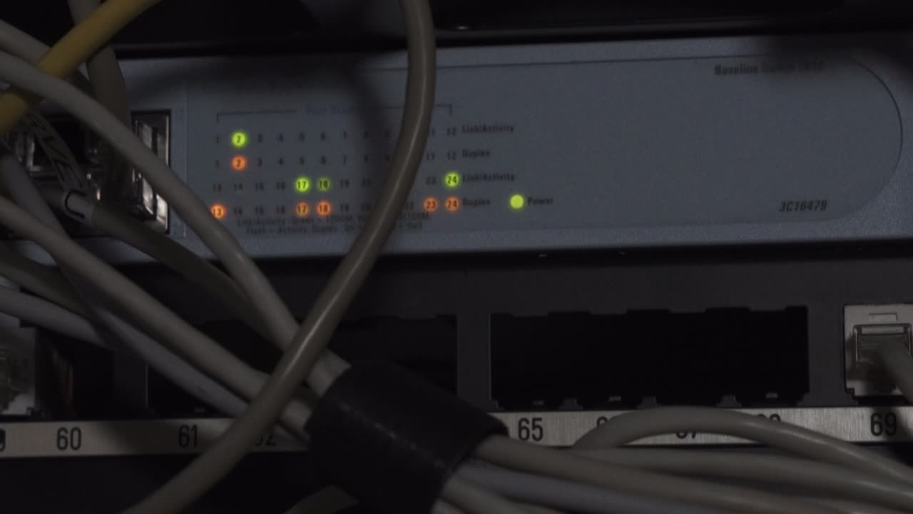 primer plano de un enrutador de datos y cables iluminados por un hacker de seguridad de red