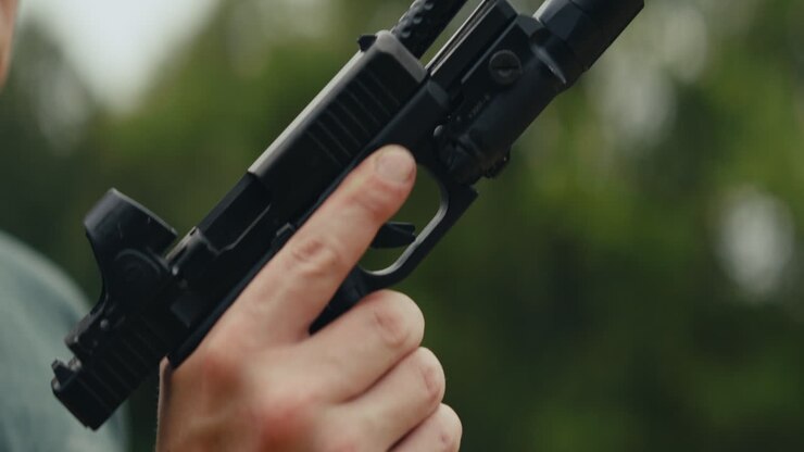 Nærbillede af en hånd, der holder en pistol