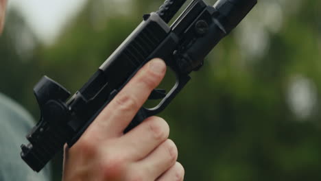 close up of hand holding pistol
