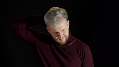 man with blonde hair, beard, and gold chain in a red sweater