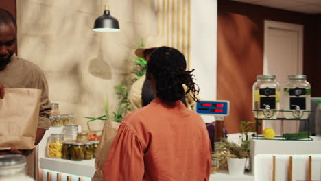 vendedor afroamericano que pesa productos para un cliente habitual en el supermercado