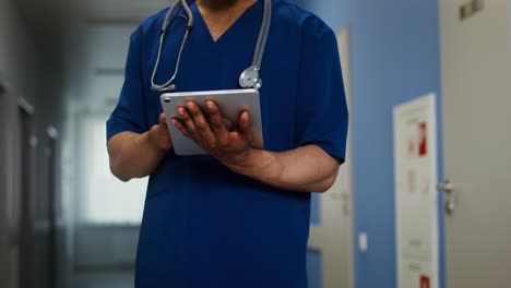 médico usando una tableta en el pasillo del hospital