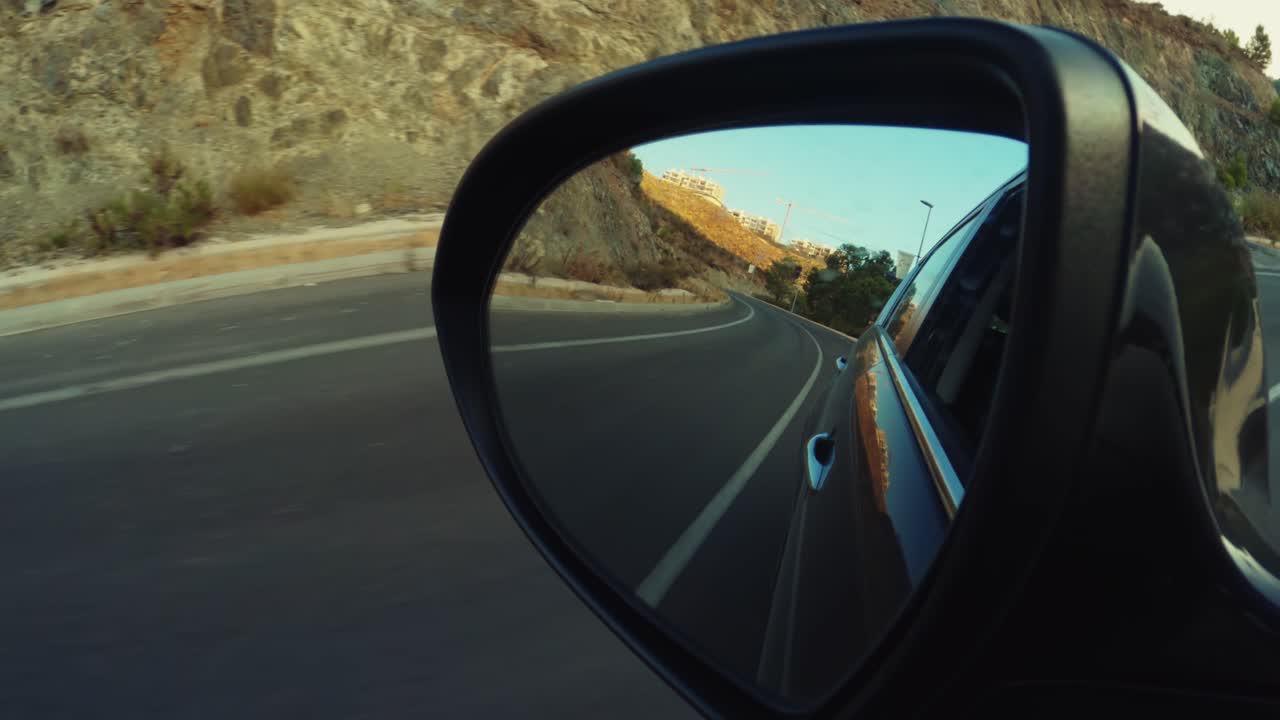 Car side mirror during a daytime trip