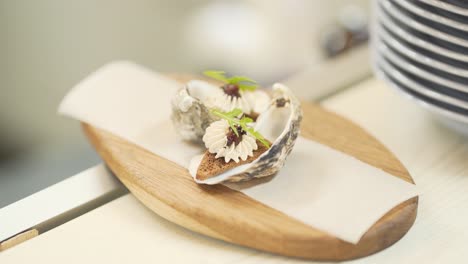 The-close-up-concept-of-oysters-in-the-shellfish-stuffed-with-greens-and-croutons-lying-on-the-wooden-plate