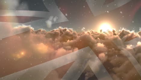 animation of union jack flag of great britain waving over sunset and clouds with falling snowflakes