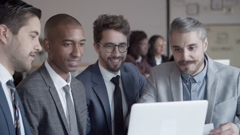 Business-people-having-conversation-with-help-of-laptop