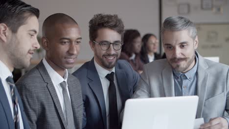 business people having conversation with help of laptop