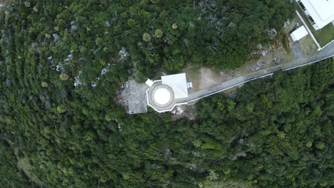 looking down on a historical lighthouse keepers accommodation surrounded by lush vegetation