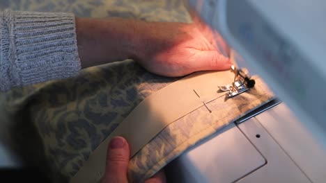 close up of woman sewing fabric in slow motion