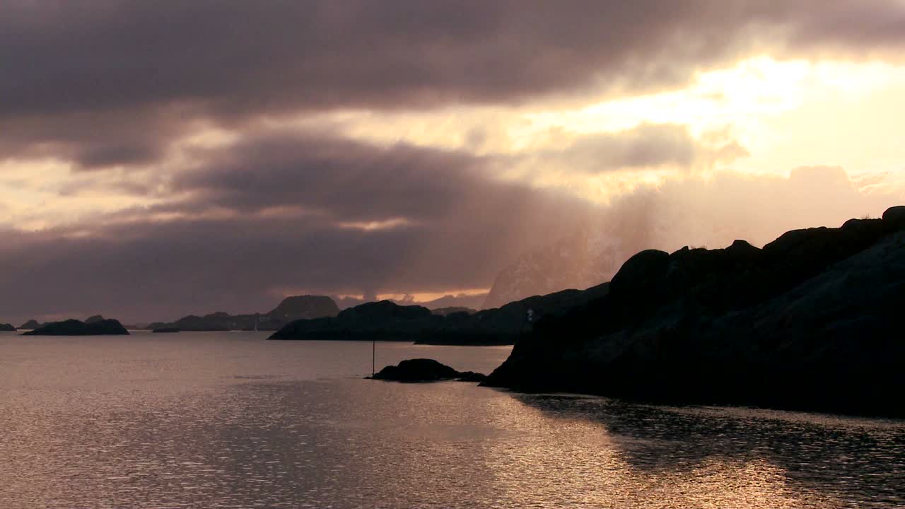 puesta de sol dorada detrás de una costa en medio de fiordos al norte del círculo polar ártico en las islas lofoten noruega