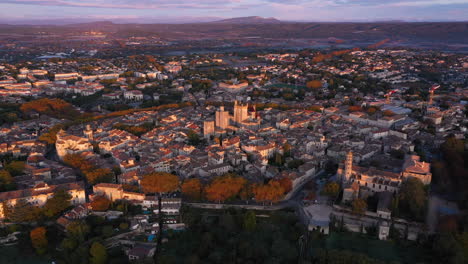 Uzès-Und-Seine-Umgebung-Luftaufnahme-Am-Frühen-Morgen-Mit-Bergen-Im-Hintergrund