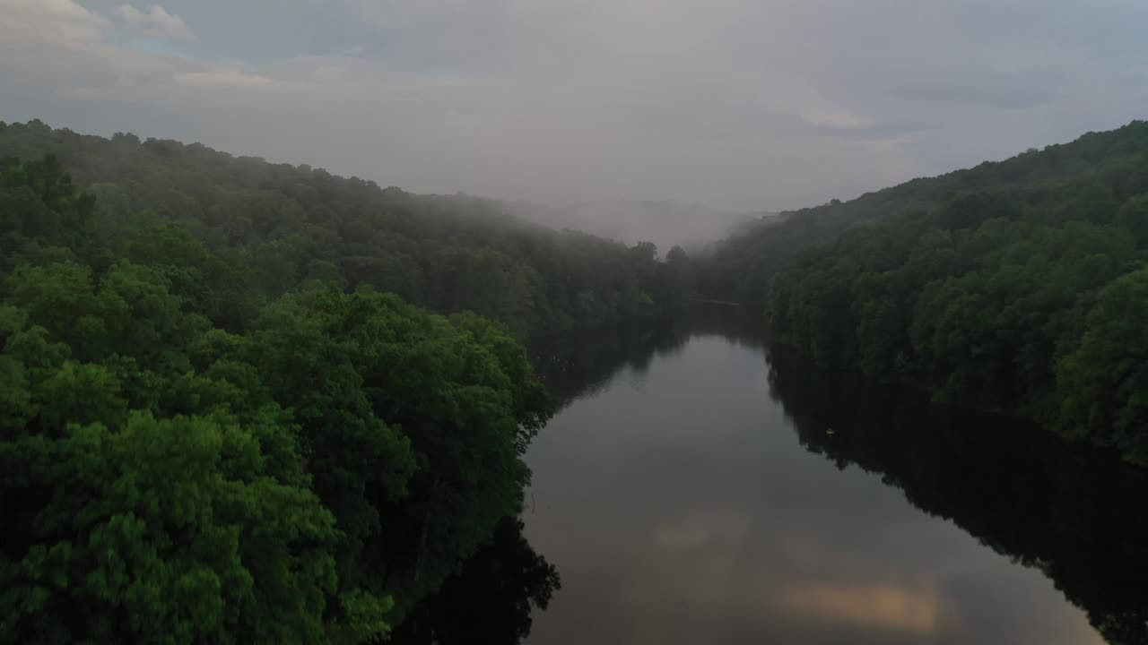 estrecho río forestal con niebla creciente a principios de la mañana de verano, vista aérea