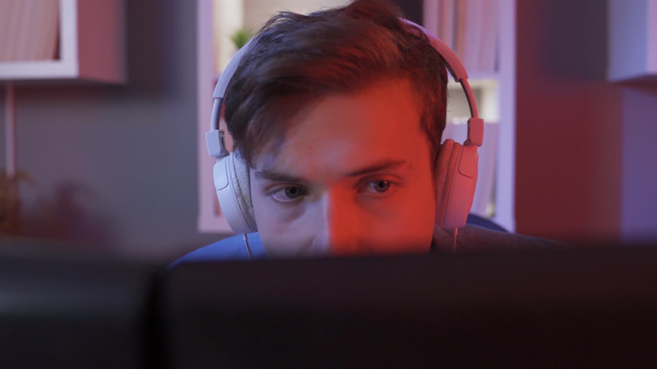 Exciting Male Gamer Playing Online Video Game on Computer.