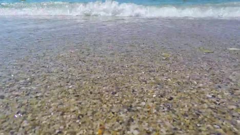 crystal clear beach water with pebbles