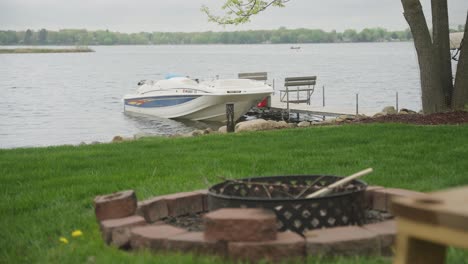 pozo de fuego en primer plano y barco en el fondo en una cabaña en el norte de minnesota