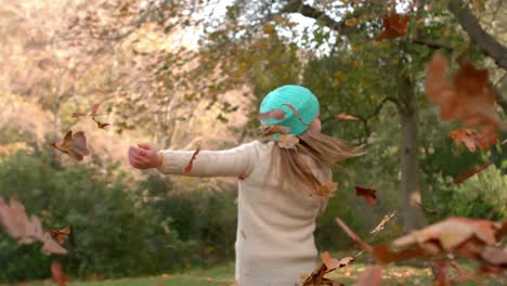 happy girl throwing leaves around