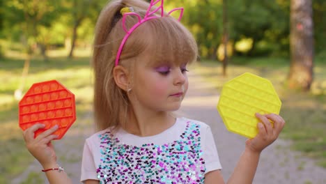 Girl-hiding-behind-two-pop-it-sensory-anti-stress-toys,-squishy-bubbles-trendy-game,-anti-stress