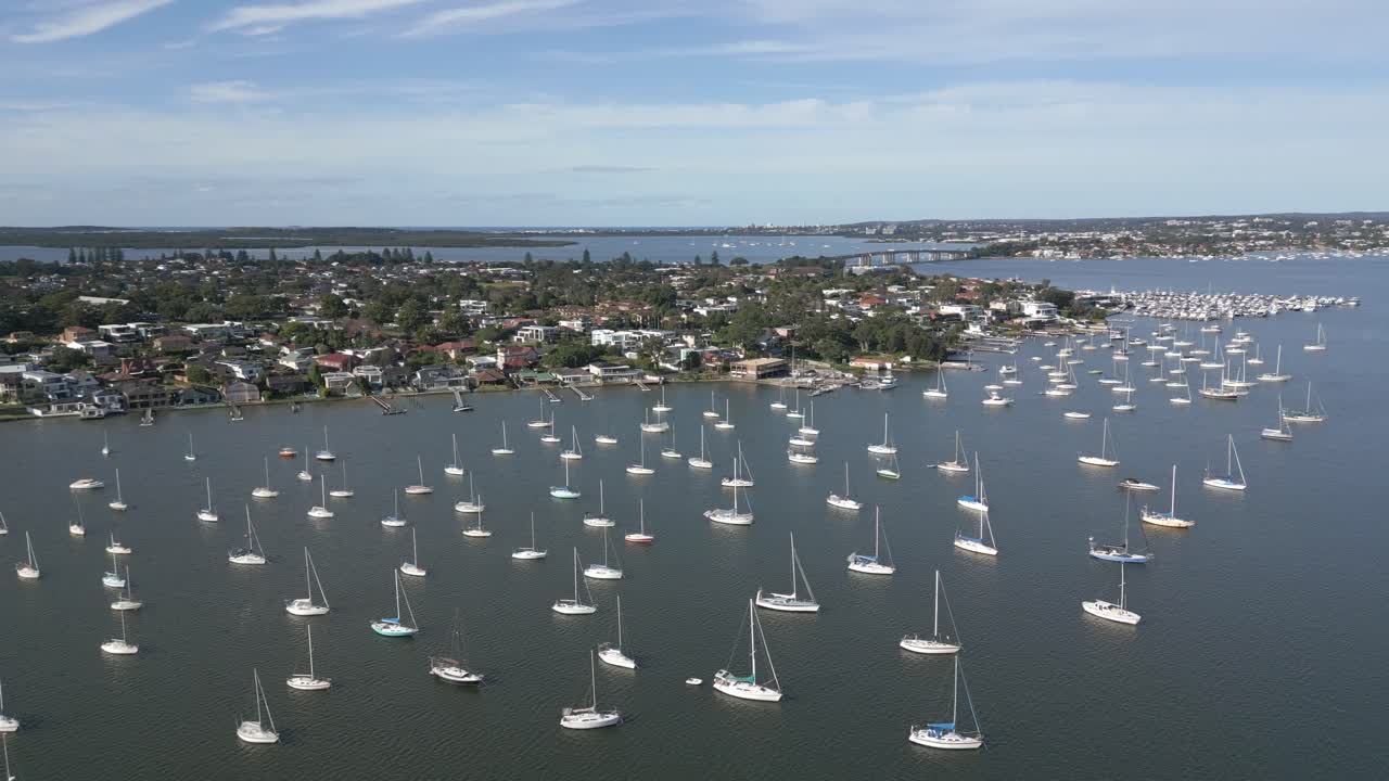 impresionante toma aérea de drones sobre el puerto deportivo de sydney en san souci, acercándose a las propiedades residenciales frente al mar y al famoso puente captain cook