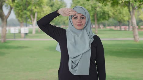 Proud-Muslim-woman-saluting-on-camera-in-park