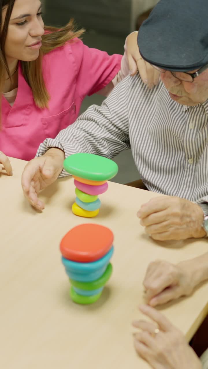 A young woman and an elderly man playing games at a table