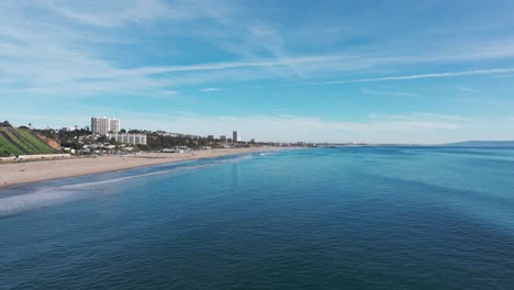 drone disparado bajo sobre el océano pacífico y la playa de santa mónica