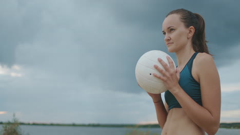 Porträt-Einer-Jungen-Sportlerin-Mit-Volleyball,-Die-Sie-Beim-Spiel-Auf-Dem-Beachvolleyballplatz-Im-Freien-Spielt