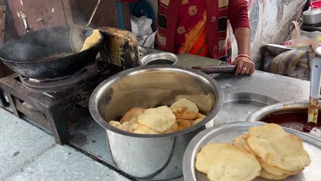 closeup shot of hardworking woman frying puri at a roadside stall in kolkata, india during winter morning