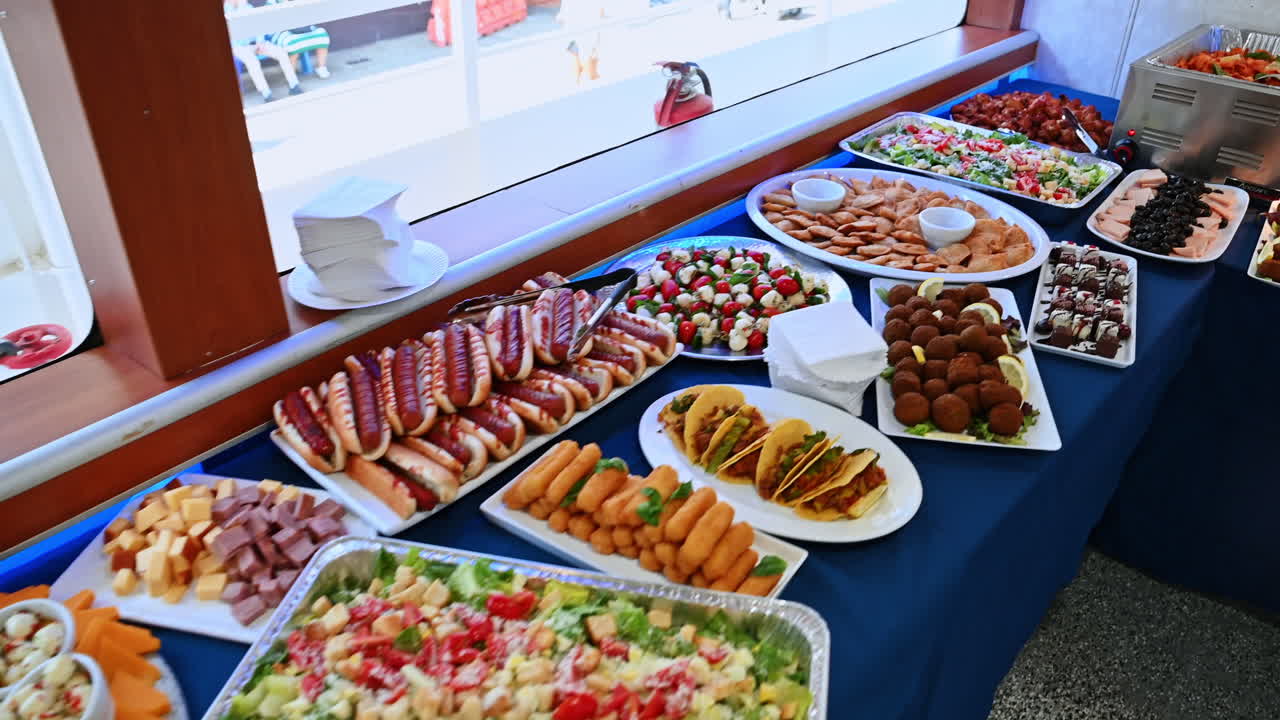 New York, USA, 1 agosto 2025: lungo tavolo da buffet con diversi piatti su una nave da crociera. Ricco buffet con carne, insalate, hot dog e dessert serviti durante un evento sulla nave da crociera.