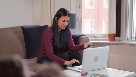 Weite-Aufnahme-Einer-Jungen-Attraktiven-Frau,-Die-Einen-Laptop-Verwendet,-Um-Online-Einzukäufe-Zu-Tätigen