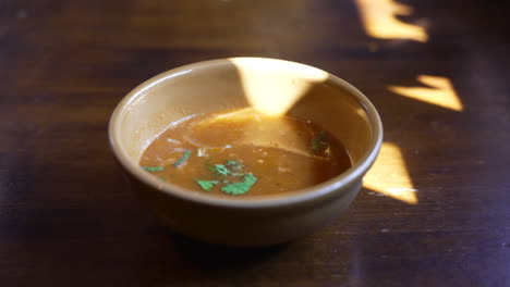 Steaming-hot-pumpkin-soup-in-brown-stoneware-bowl