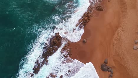 Aerial-top-shot-of-a-coastline-where-the-ocean-meets-the-shore