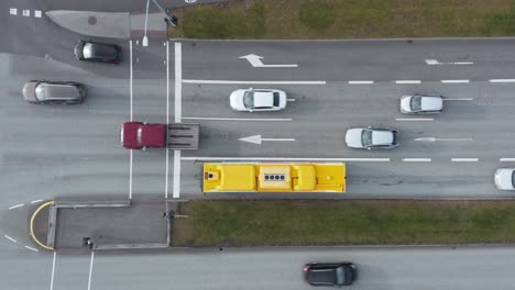 cars moving along crossing intersection during green traffic light, yellow public transport bus, top down