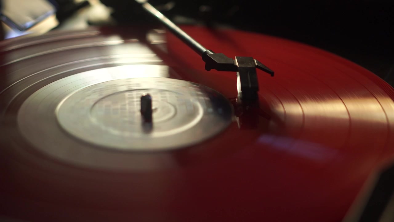 Riproduzione di un disco in vinile rosso Long Play e arresto automatico, puntina e giradischi in rotazione