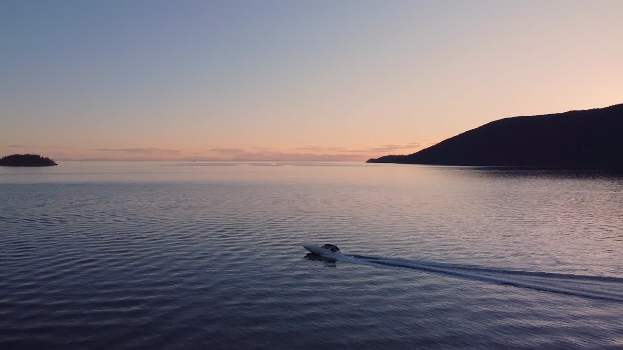Aerial of motorboat cruising into the sunset (BC)