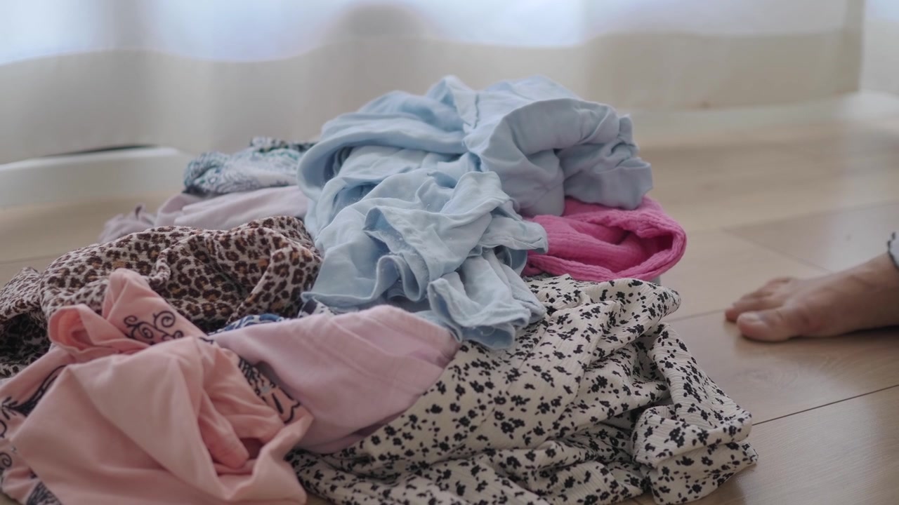 Person Picking Up Clothes From Floor at Home